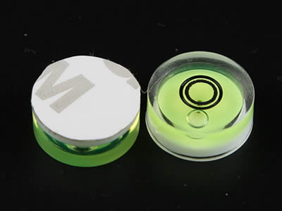 A top view and a bottom view of plastic bubble level vial with adhesive.